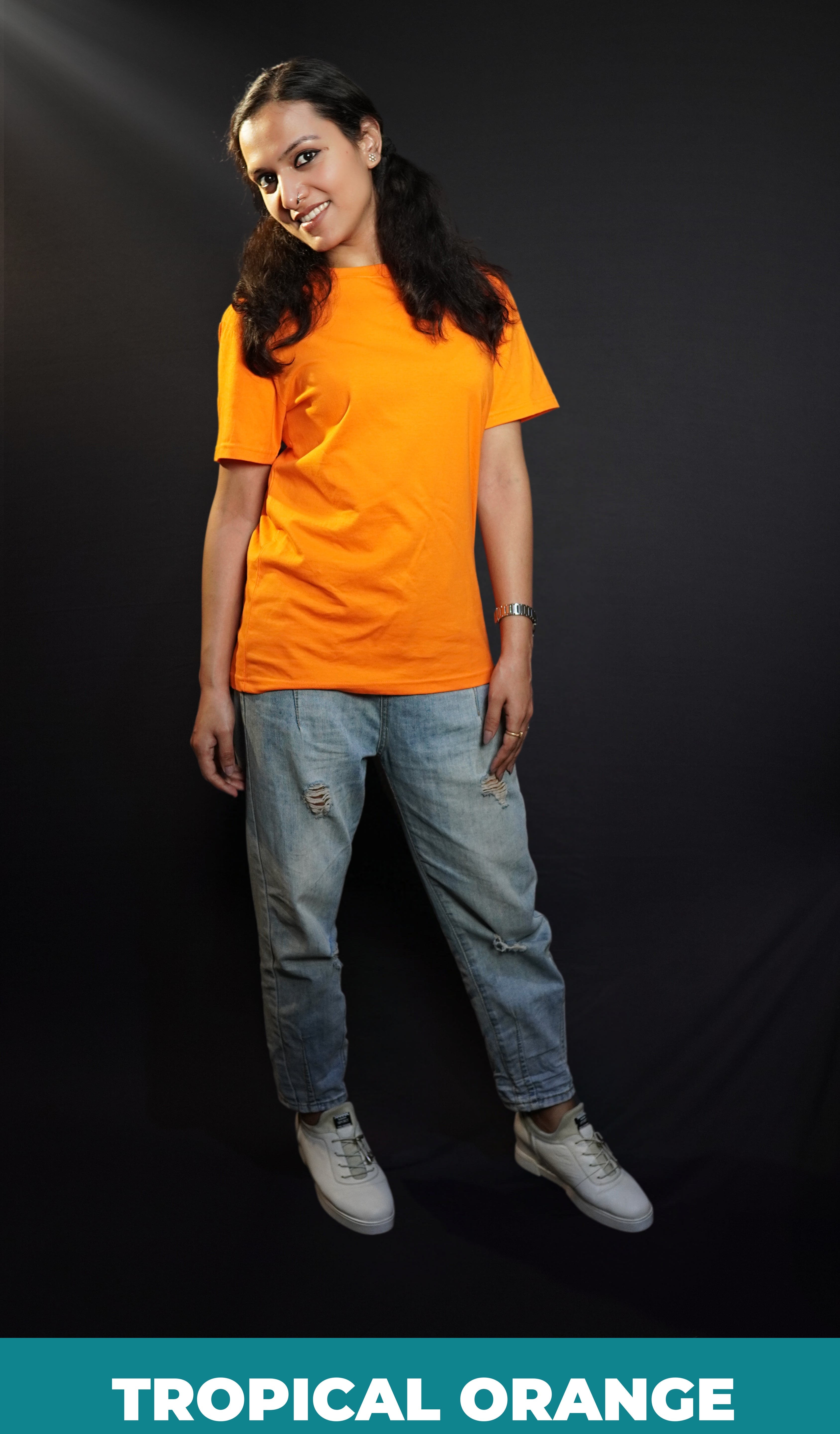 A woman smiling brightly with her head bending sideways, wearing an adult's plus size stretchable tropical orange t-shirt, showcasing a trendy baggy fit-Muselot