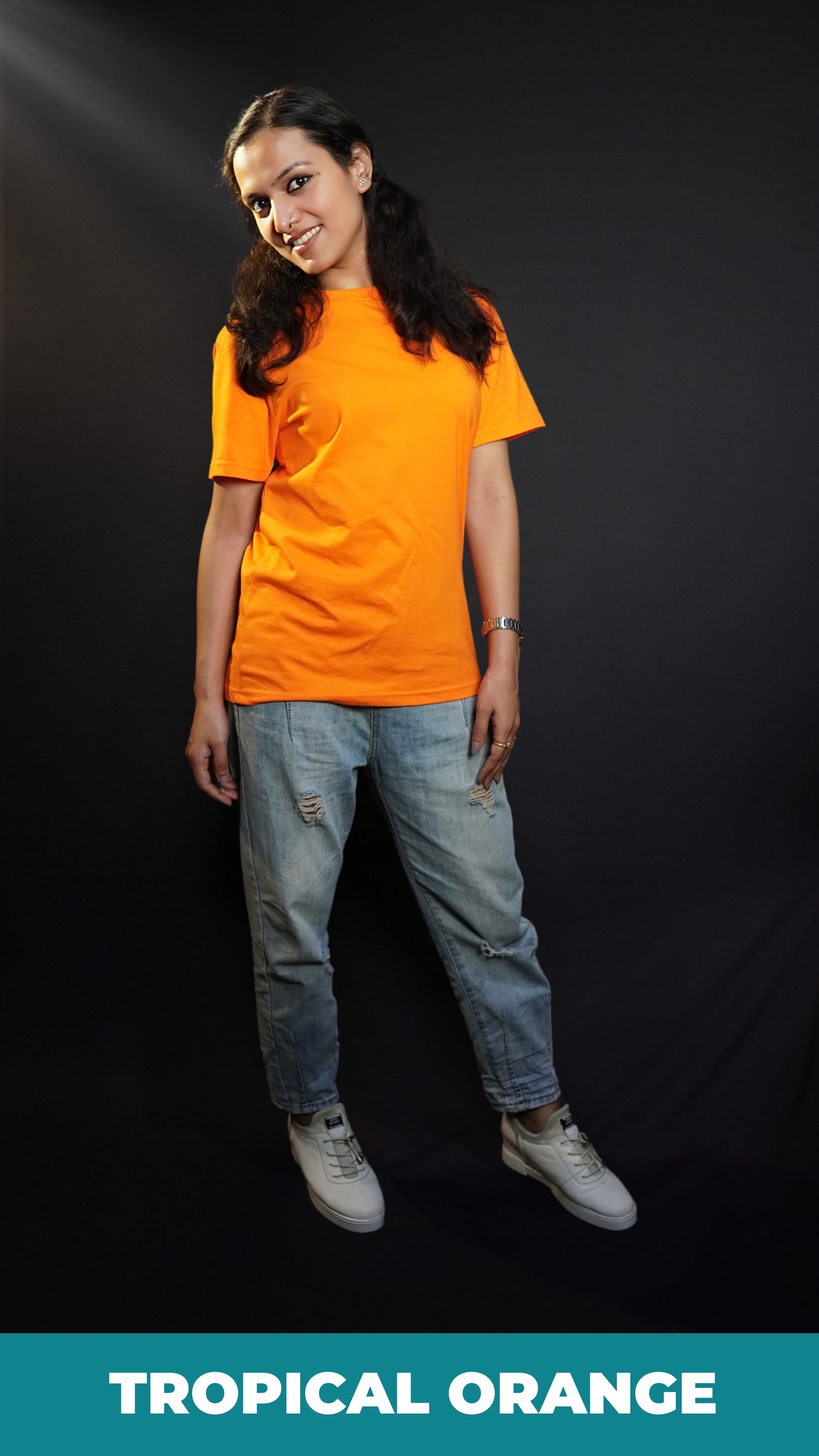 A woman smiling brightly with her head bending sideways, wearing an adult's plus size stretchable tropical orange t-shirt, showcasing a trendy baggy fit-Muselot