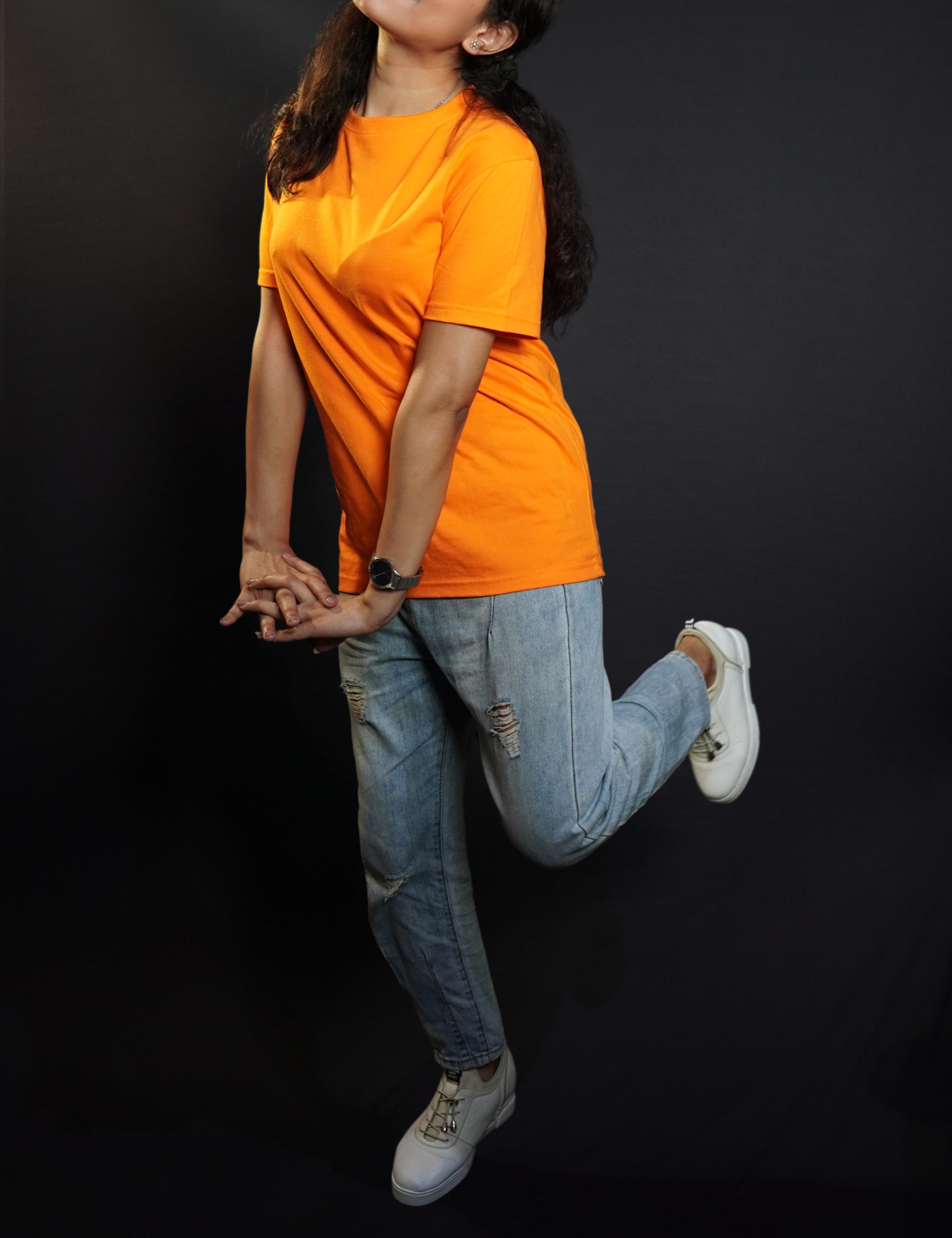A happy woman wearing a plain moisture wicking round neck girl's t-shirt, posing with her hands stretched in front of her with fingers intertwined with each other, showcasing a comfortable snug fit-Muselot