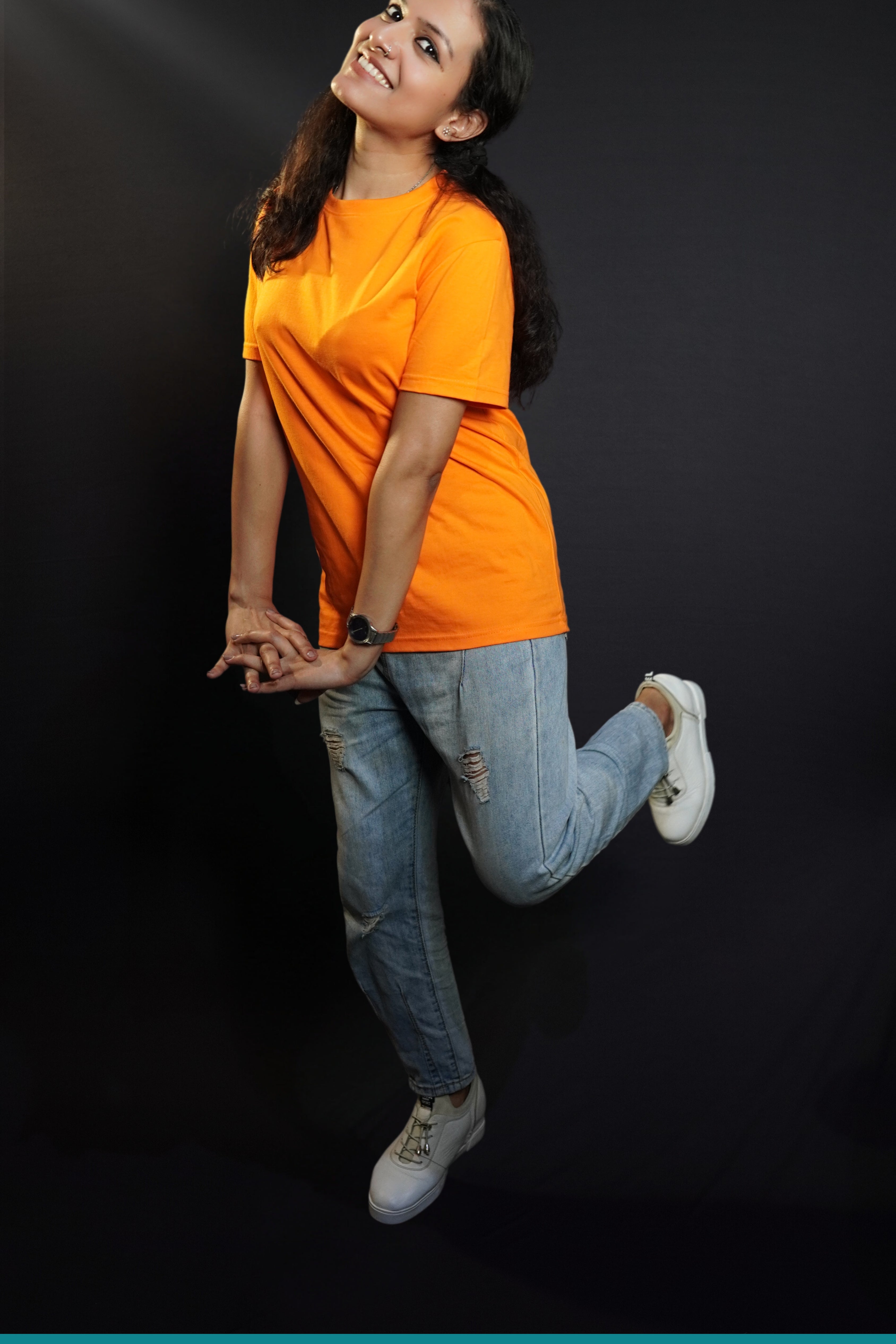 A happy woman wearing a plain moisture wicking round neck girl's t-shirt, posing with her hands stretched in front of her with fingers intertwined with each other, showcasing a comfortable snug fit-Muselot