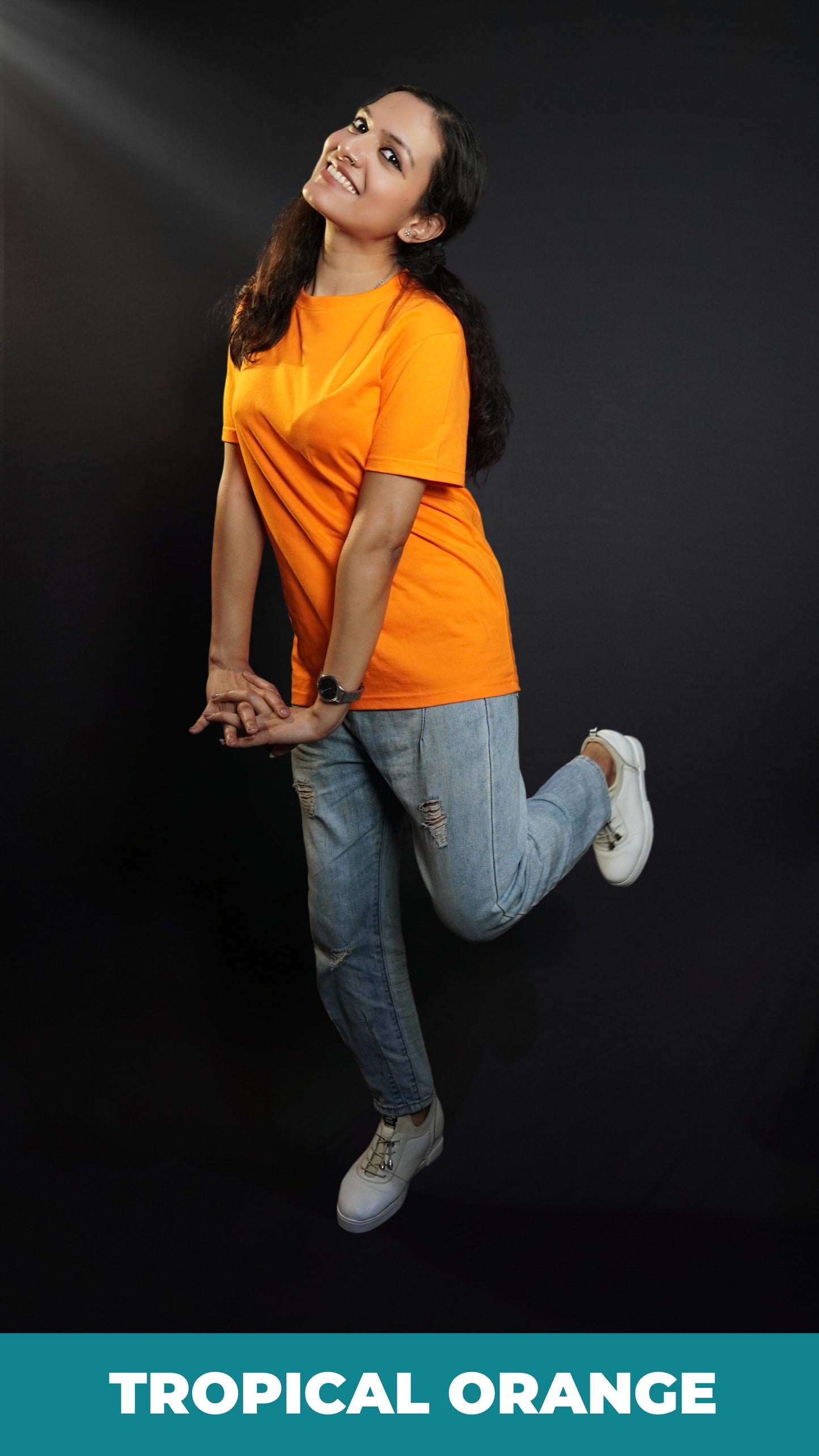 A happy woman wearing a plain moisture wicking round neck girl's t-shirt, posing with her hands stretched in front of her with fingers intertwined with each other, showcasing a comfortable snug fit-Muselot