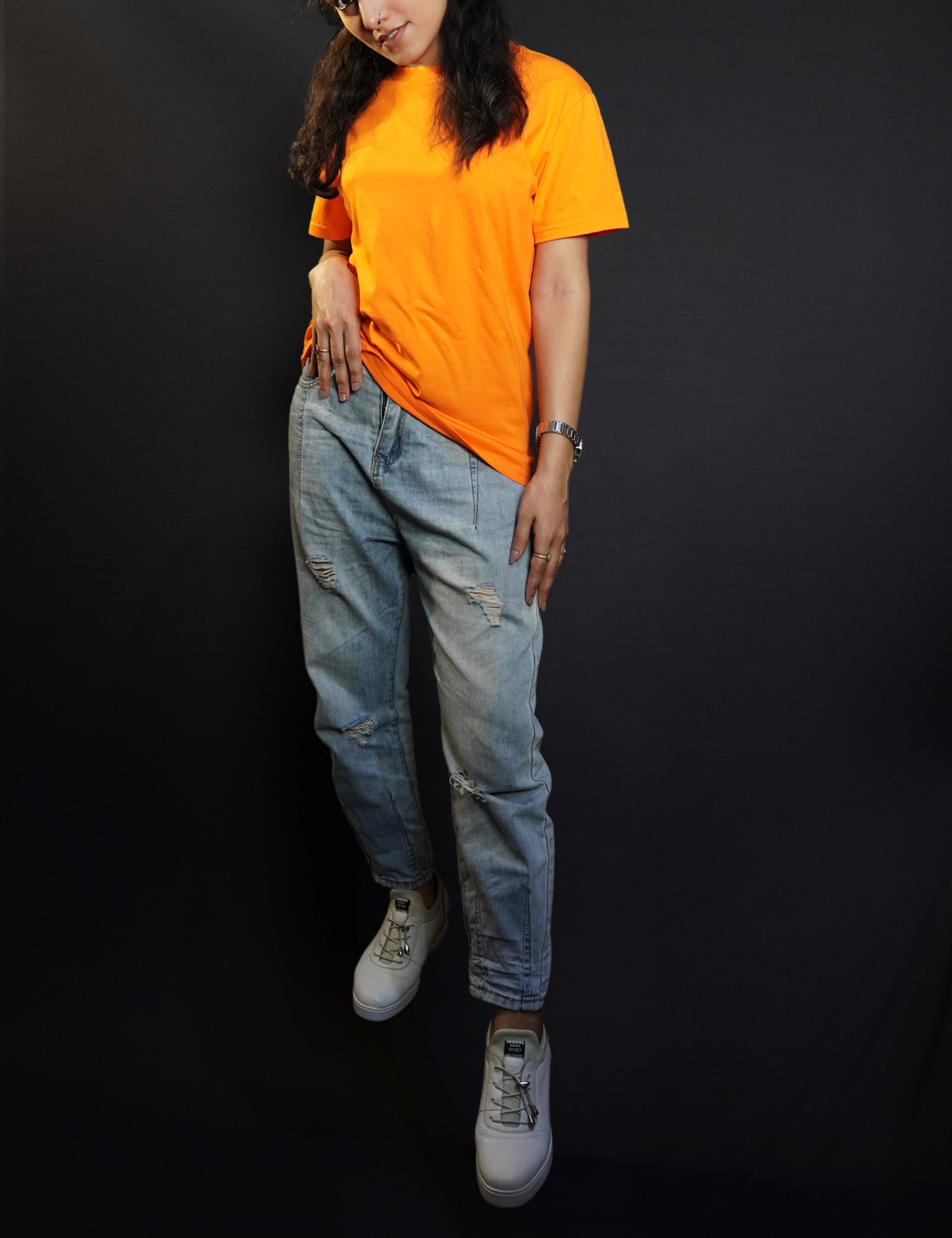 A woman wearing a small size round neck quick drying short sleeved t-shirt, posing with her hand on her waist and head bent down a little, showcasing a up to the minute casual fit-Muselot