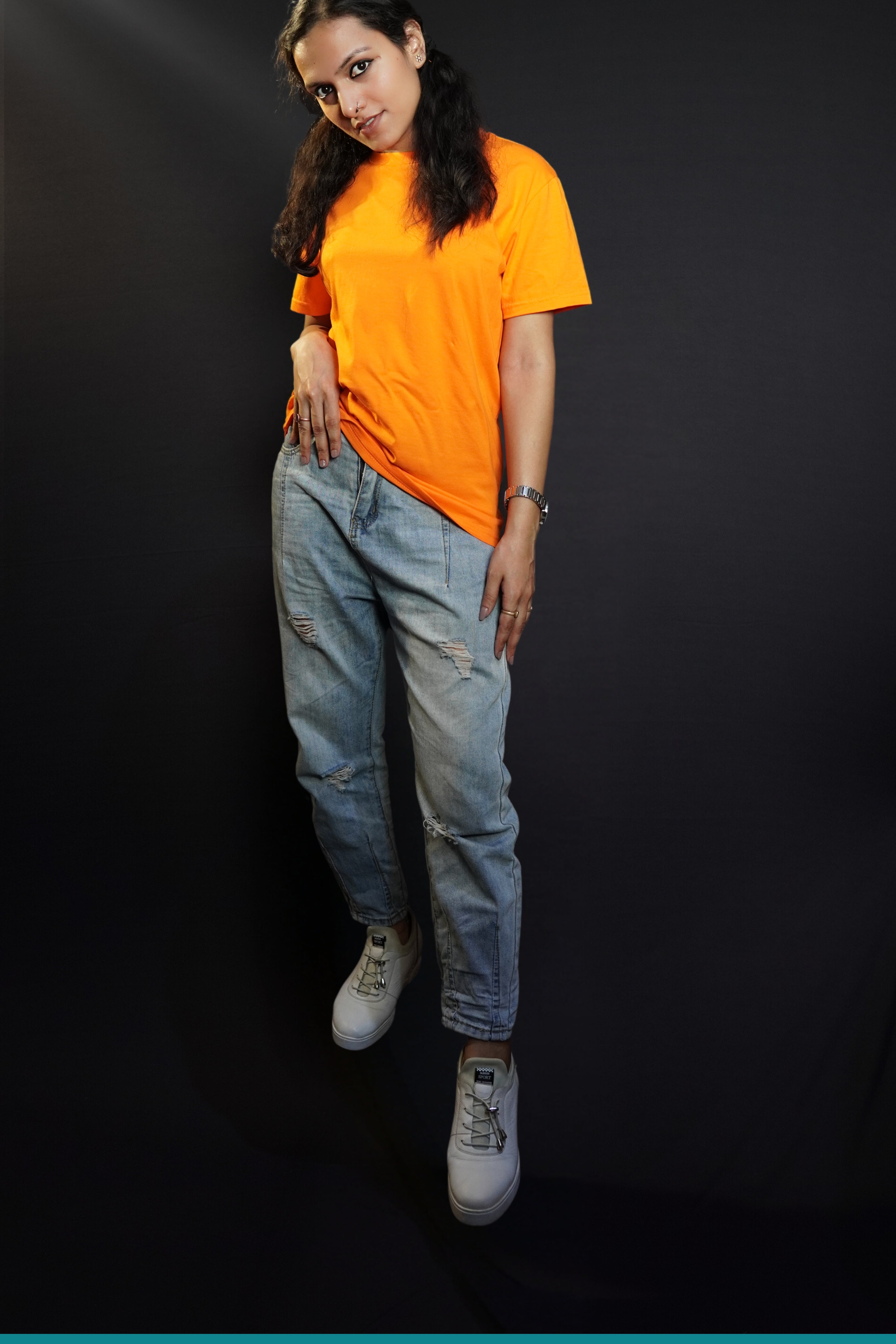 A woman wearing a small size round neck quick drying short sleeved t-shirt, posing with her hand on her waist and head bent down a little, showcasing a up to the minute casual fit-Muselot