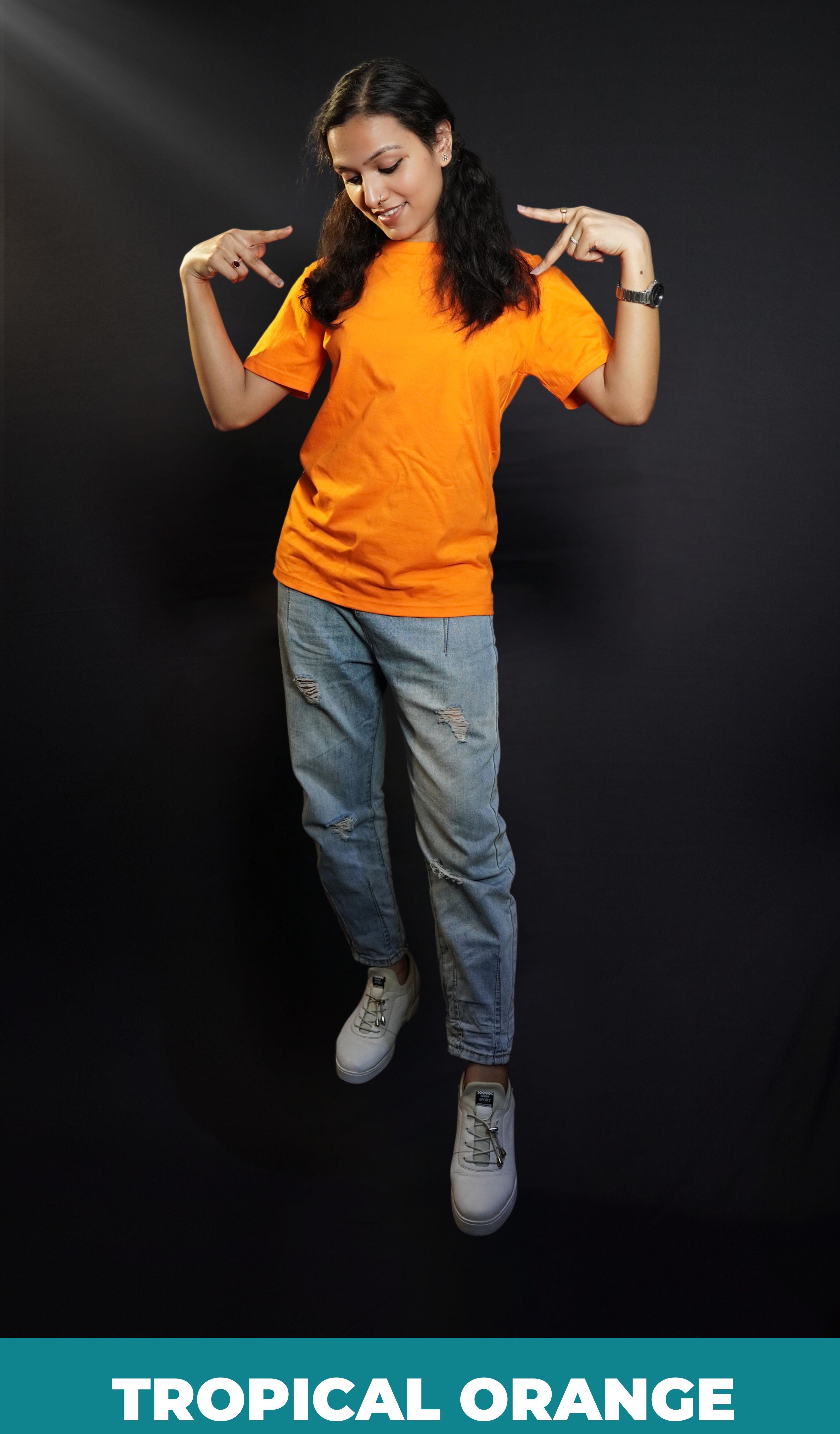 A stylish woman wearing a long length stretchable tropical orange plain extra large t-shirt, posing with her hands upon her shoulders making a v sign with her fingers, highlighting a bright everyday look-Muselot