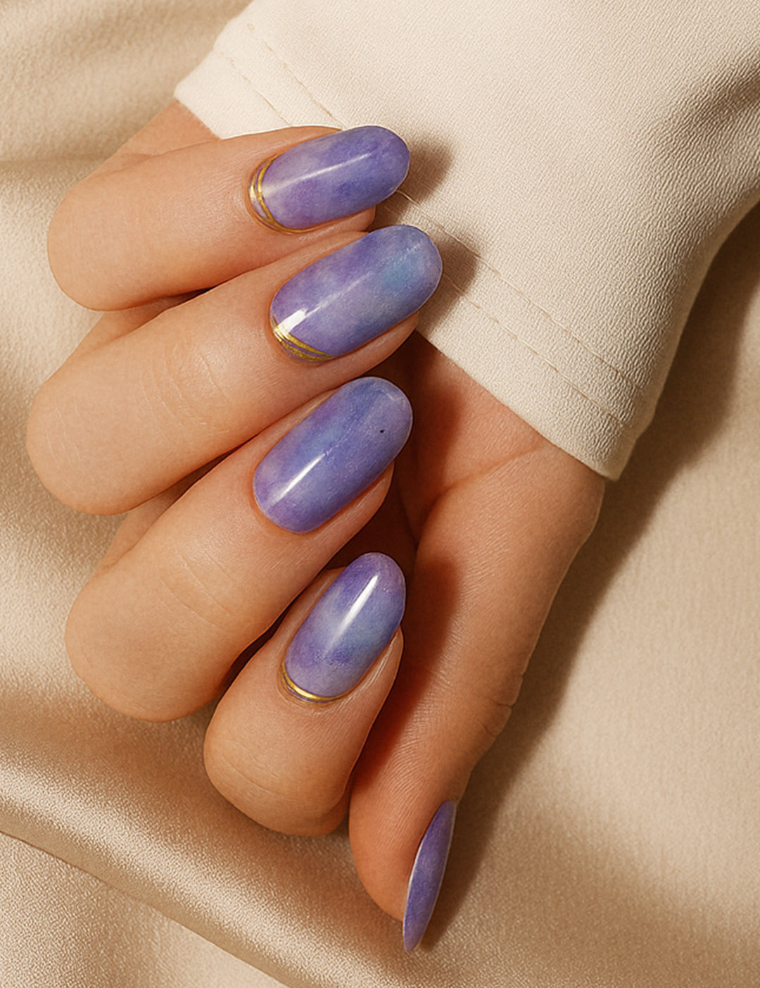 A model hand wearing Wavy Dream Lavender Marble Nail Art Stickies, showcasing a soft lavender marble design with subtle cloudy textures and elegant golden wave accents, adding a dreamy and artistic touch to the manicure-Muselot