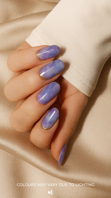 A model hand wearing Wavy Dream Lavender Marble Nail Art Stickies, showcasing a soft lavender marble design with subtle cloudy textures and elegant golden wave accents, adding a dreamy and artistic touch to the manicure-Muselot