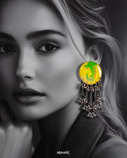 Close-up of a woman wearing the Zarangi handmade drop chain earrings, highlighting the glossy yellow-green circular top paired with cascading silver chains and jingling ghungroos, offering a vibrant statement look — Muselot.