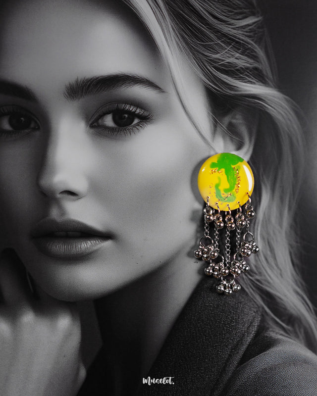 Close-up of a woman wearing the Zarangi handmade drop chain earrings, highlighting the glossy yellow-green circular top paired with cascading silver chains and jingling ghungroos, offering a vibrant statement look — Muselot.