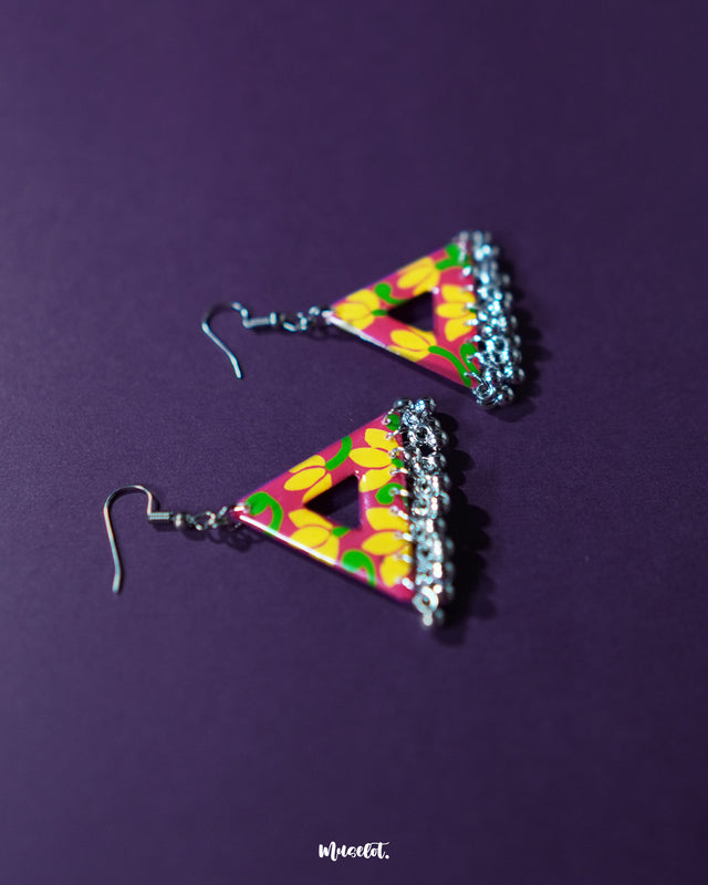 A close-up of the Zarmin triangle floral earrings capturing the intricate hand-painted floral details in pink and yellow, with dangling silver jhumkis adding depth and a touch of ethnic elegance — Muselot.