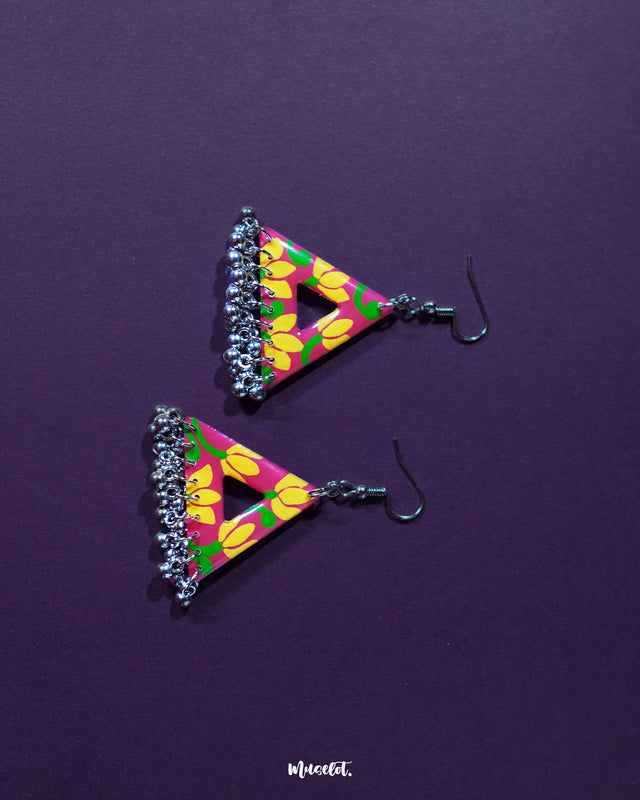 Zarmin triangle floral earrings shown laid flat against a soft background, highlighting the delicate floral patterns and triangular shape, with oxidized silver detailing and tiny jhumkis adding to their artisanal charm — Muselot.