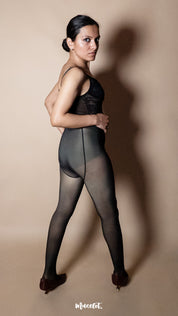 A model wearing black 50 denier tights close-up on a neutral studio background, highlighting breathable fabric, soft texture and even skin-like appearance — Muselot