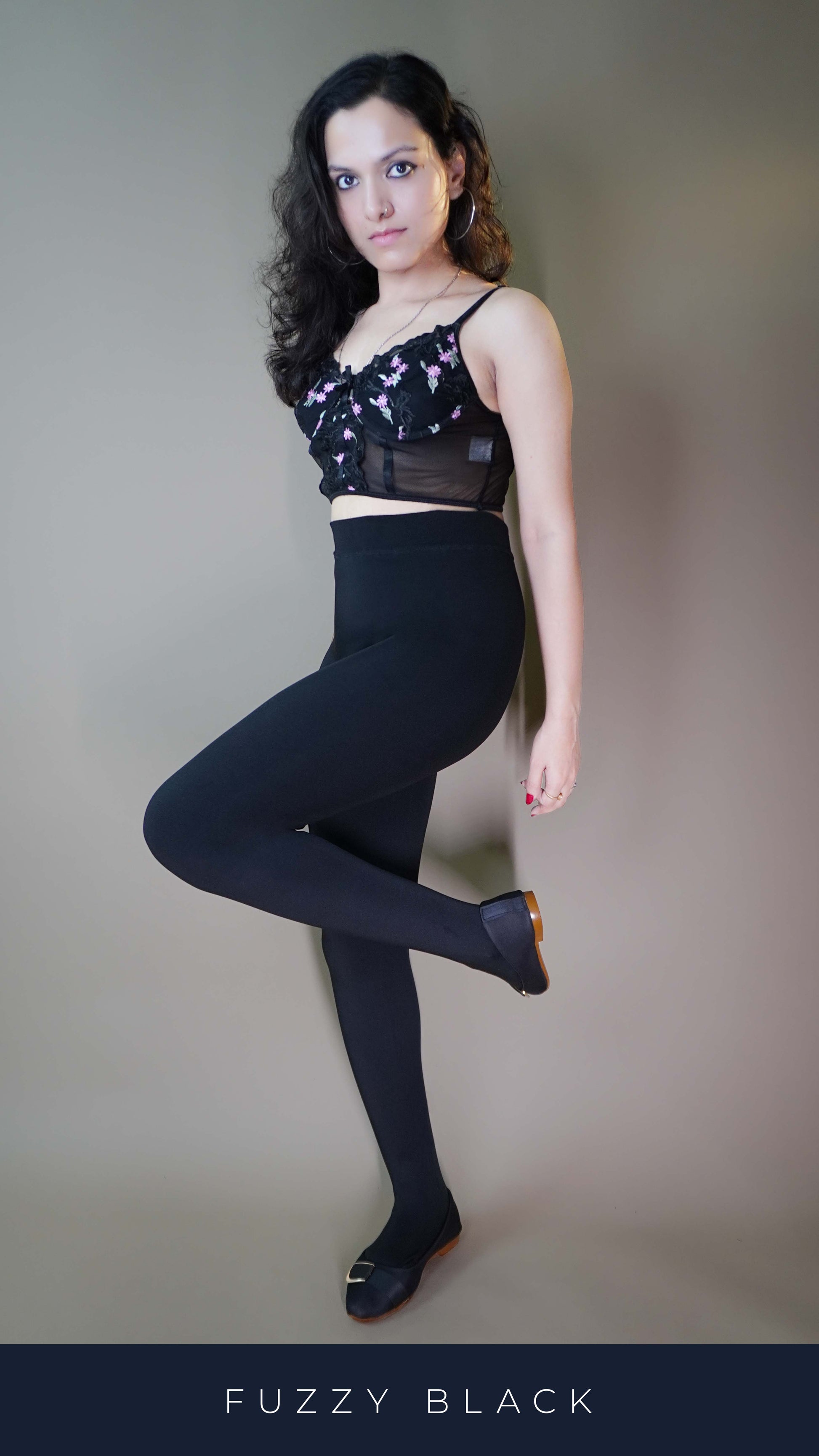 A stylish model wearing a body-hugging black warm tights, offering a sleek, form-fitting silhouette while providing comfort and warmth. The tights perfectly complement the model's figure, making them a stylish and cozy choice for any occasion. -Muselot