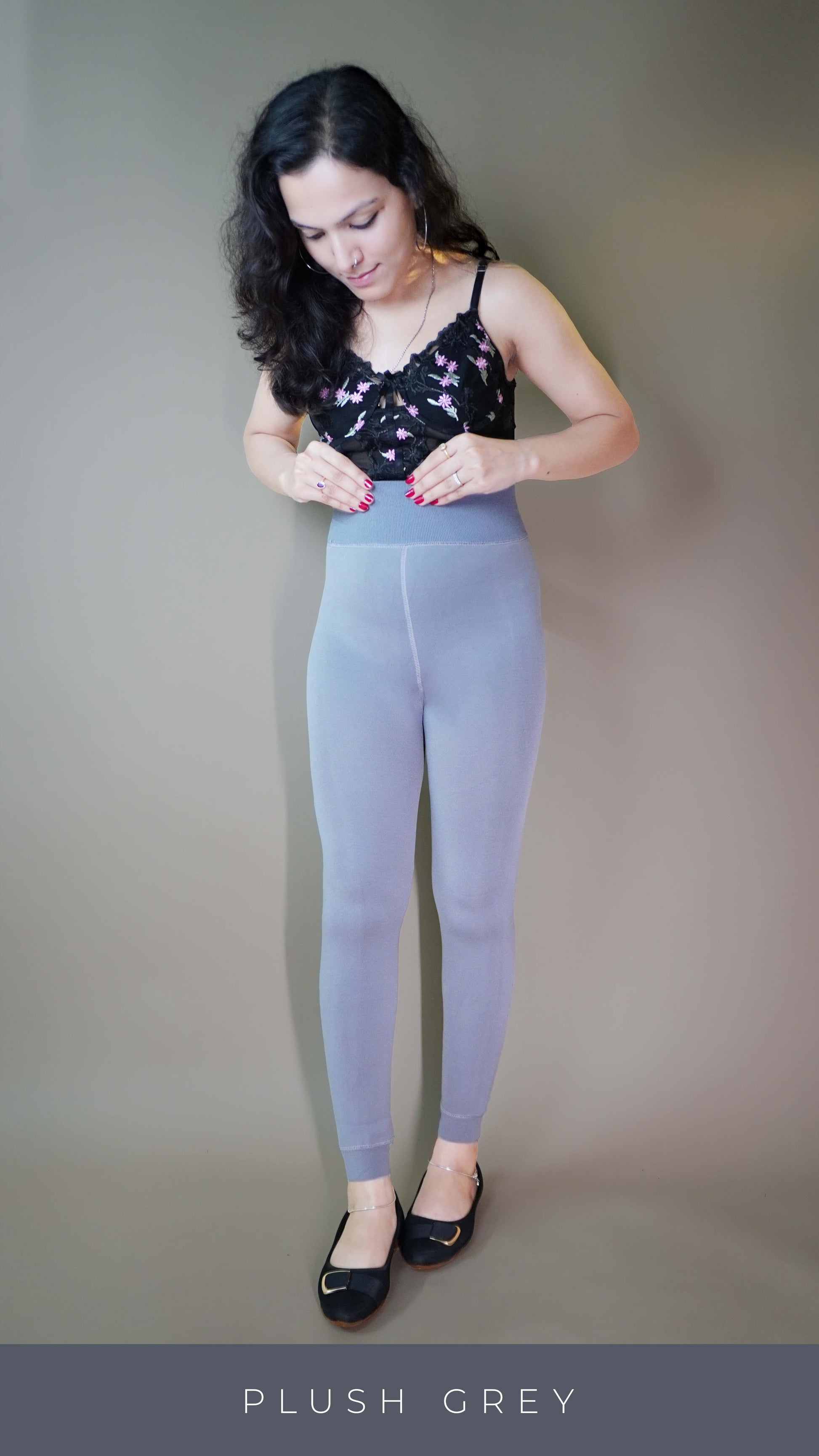 A model, wearing body-hugging grey warm tights, showcasing their snug, flattering fit that contours to the body while offering warmth and comfort. The grey color highlights a stylish, versatile design ideal for various outfits and occasions. -Muselot