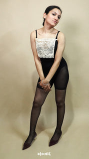 full body view of woman wearing beige lace camisole insert over black outfit on beige background, showcasing clean neckline coverage with wide lace mock camisole for deep neck styling – muselot