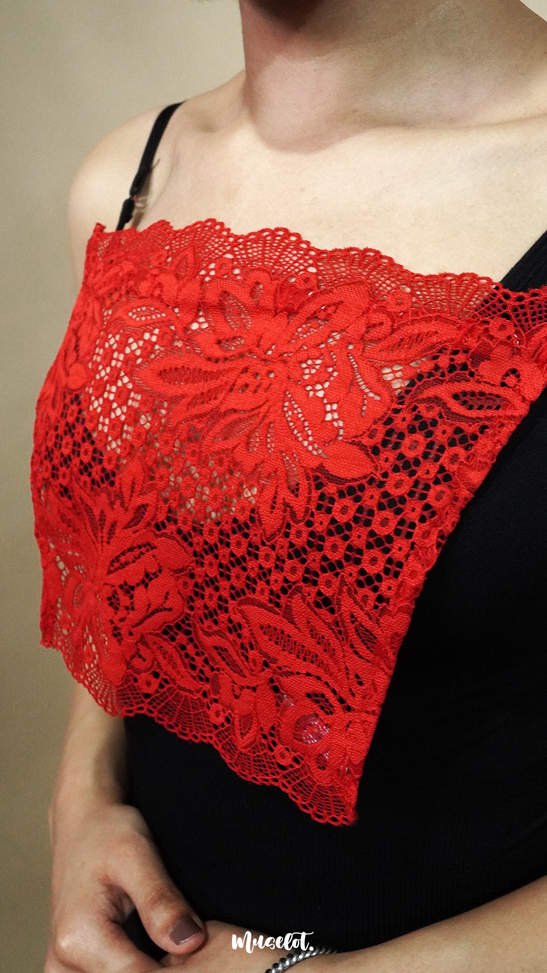 side close up of woman wearing red lace camisole insert over black top on beige background, highlighting wide lace design for better coverage on low neckline outfits – muselot