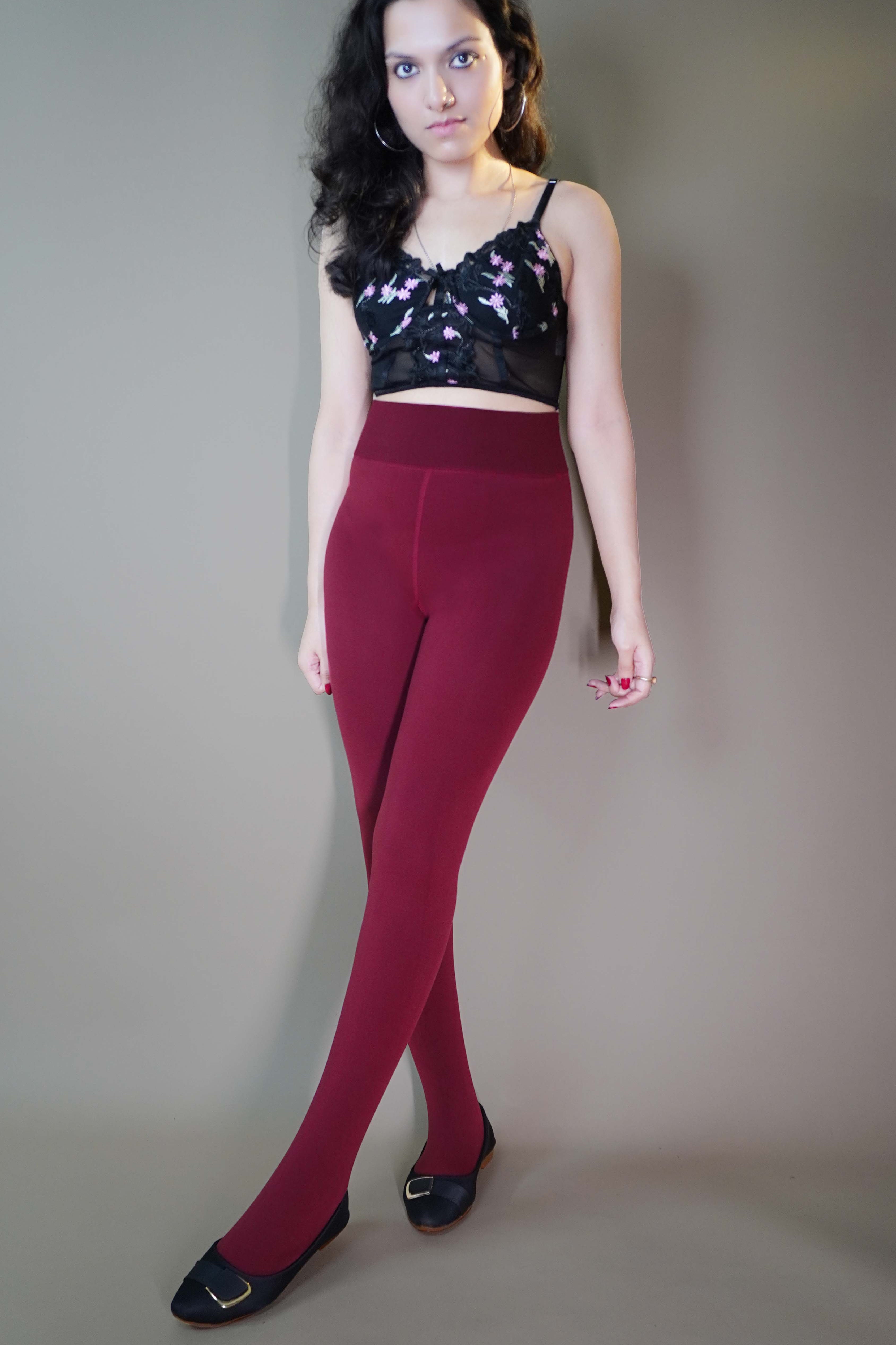 A model, wearing closed-feet berry maroon warm stockings, is highlighting their luxurious, soft texture and snug fit. The deep berry color stands out, adding warmth and style, while the closed-feet design provides full coverage for extra comfort. -Muselot