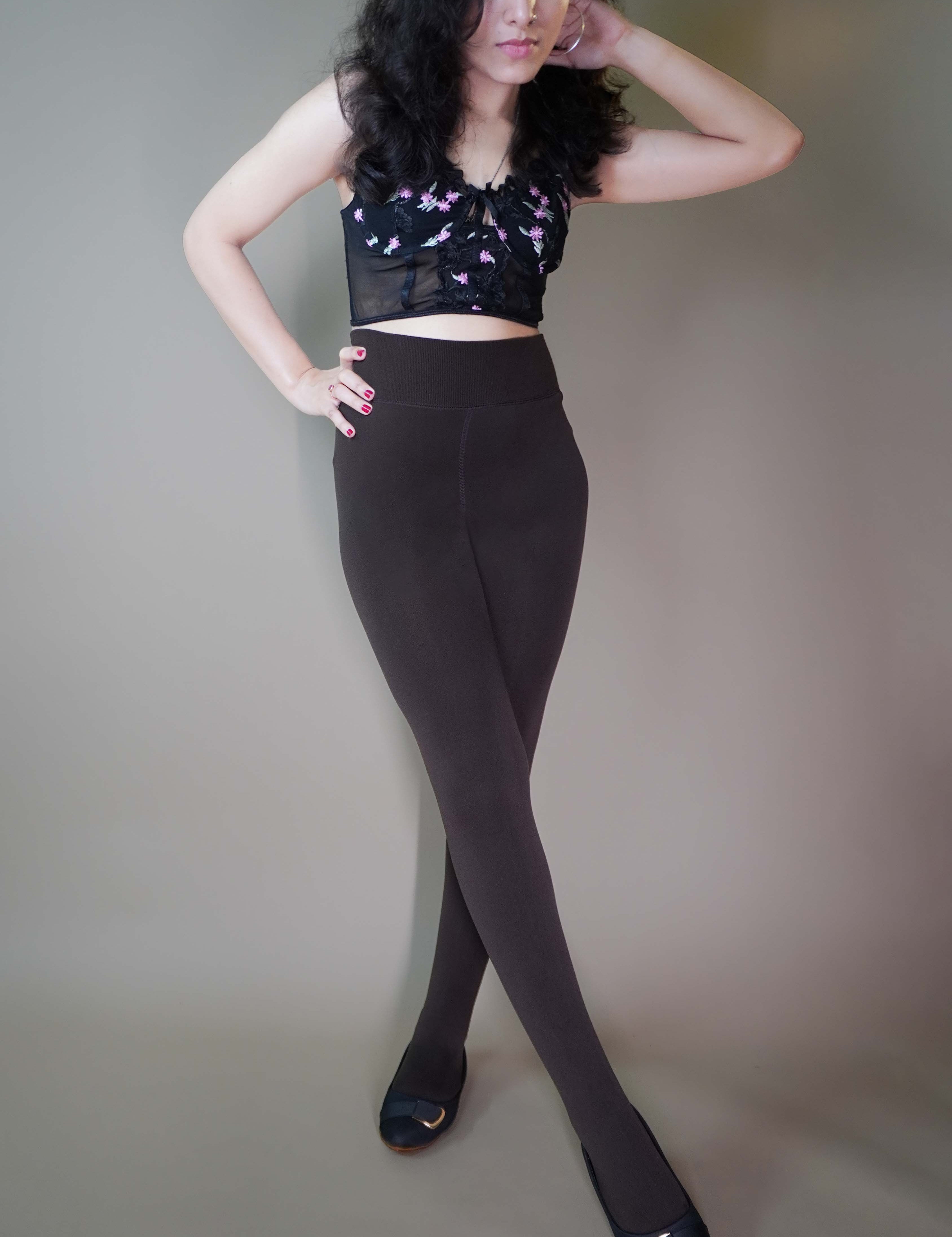 A model, wearing closed-feet dark brown warm stockings, is showcasing their thick, insulating fabric that offers both warmth and comfort. The deep dark brown color highlights a sleek, full-coverage design, making them a stylish and cozy choice for colder days. -Muselot