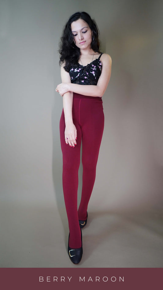 A model, wearing comfy warm berry maroon tights, is showcasing their soft, cozy fabric that provides a perfect balance of comfort and warmth. The rich berry maroon color highlights a stylish and practical design, ideal for layering or wearing solo. -Muselot