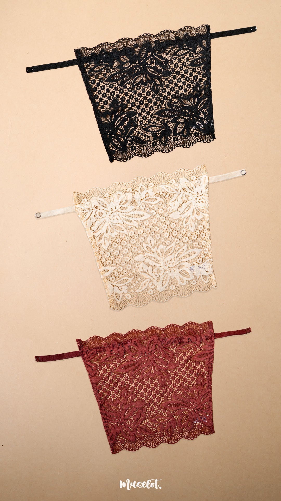 Three lace clip-on neckline covers in black, beige and burgundy displayed on a beige background, featuring rich floral lace patterns, adjustable straps and elegant neckline coverage. Perfect for deep neck tops, dresses and blouses, these breathable mock camisole inserts add a sophisticated layered look while providing comfortable coverage without adding bulk – Muselot
