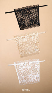 Three lace clip-on neckline covers in black, beige and white displayed on a beige background, featuring elegant floral lace patterns and adjustable straps. These deep neck cover-ups offer stylish neckline coverage for low-cut tops, dresses and blouses while adding a fashionable layered look without the bulk of a full camisole – Muselot