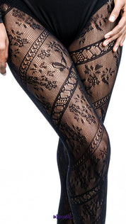 Zoom in shot of a model wearing black patterned tights standing against a white background, showcasing full coverage lace stockings - Muselot