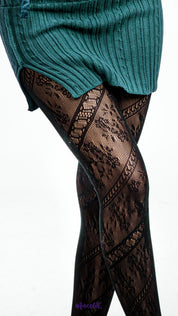 A model wearing black lace stockings with detailed floral fishnet texture on a white background, close up highlighting intricate mesh pattern - Muselot