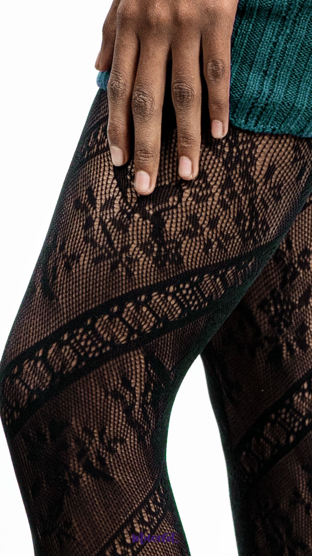 A model wearing black lace pantyhose with floral mesh design on a white background, close up shot highlighting pattern detail - Muselot