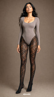 A woman wearing full-length black floral fishnet stockings with diagonal lace detailing and sheer patterned panels from waist to toe - Muselot