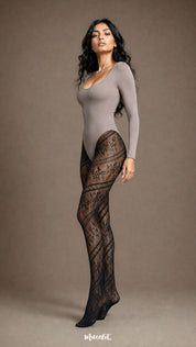 Side profile of a woman wearing black designer lace stockings with semi-sheer floral patterning, diagonal lace bands and covered feet - Muselot