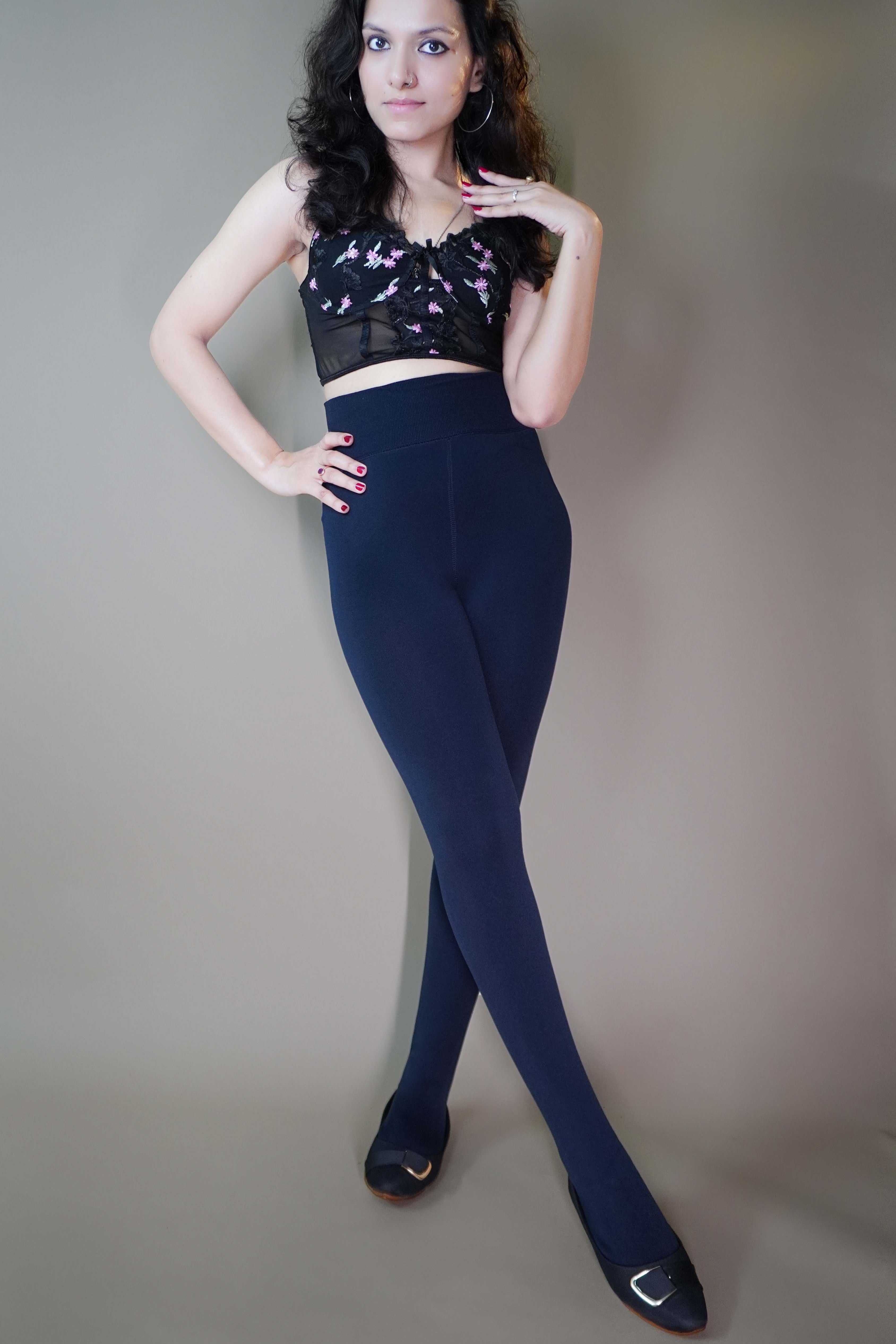 A model wearing  dusk blue furry tights paired with a trendy crop top, effortlessly blending warmth and fashion. The plush texture of the tights complements the chic crop top, making it a perfect statement for cozy winter style. -Muselot






