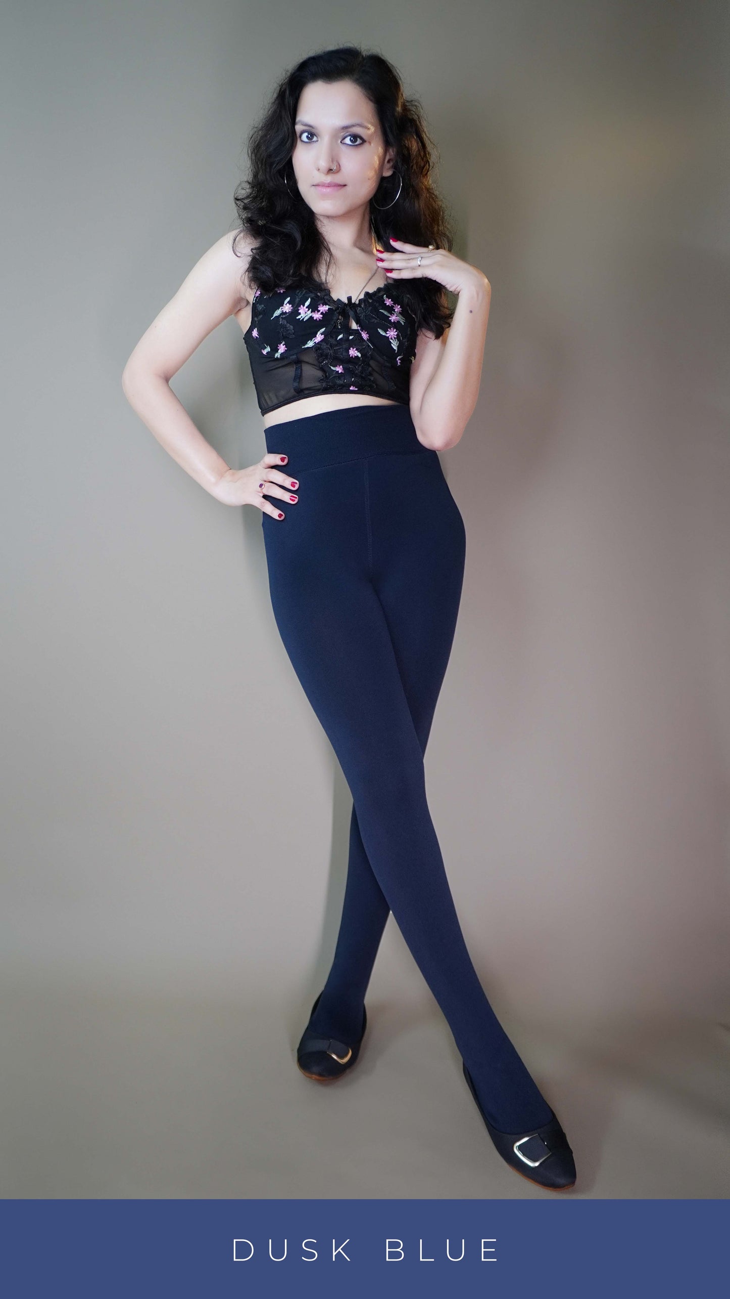 A model wearing  dusk blue furry tights paired with a trendy crop top, effortlessly blending warmth and fashion. The plush texture of the tights complements the chic crop top, making it a perfect statement for cozy winter style. -Muselot






