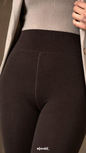Close-up of dark brown fur lined winter stockings showing the wide ribbed high waistband, centre seam and smooth opaque fabric.