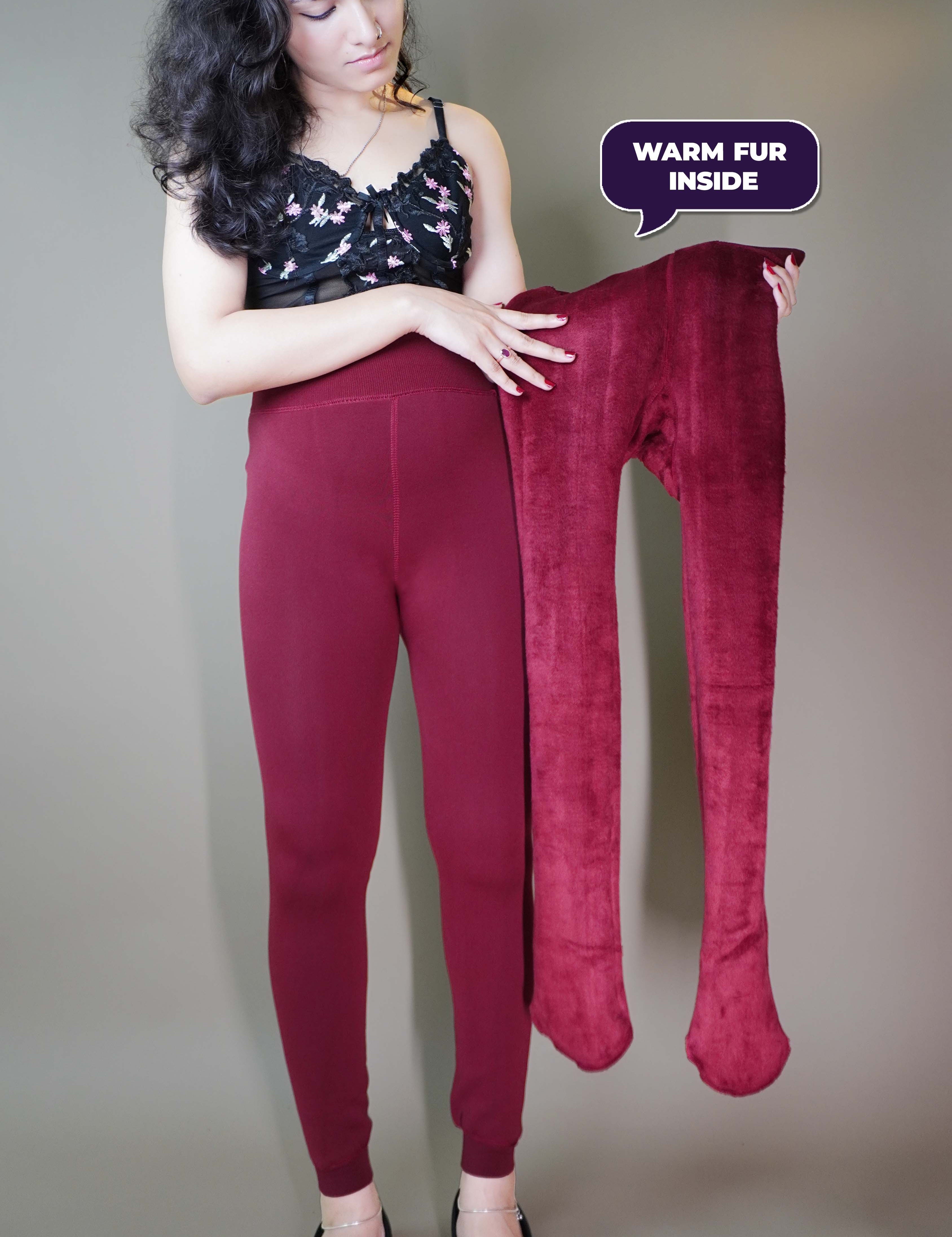 A model, wearing furry berry maroon stockings, and also holding  the tights inside out, showcasing  its plush fur texture. The rich berry color enhances the cozy, luxurious feel, highlighting the softness and warmth of the tights. -Muselot