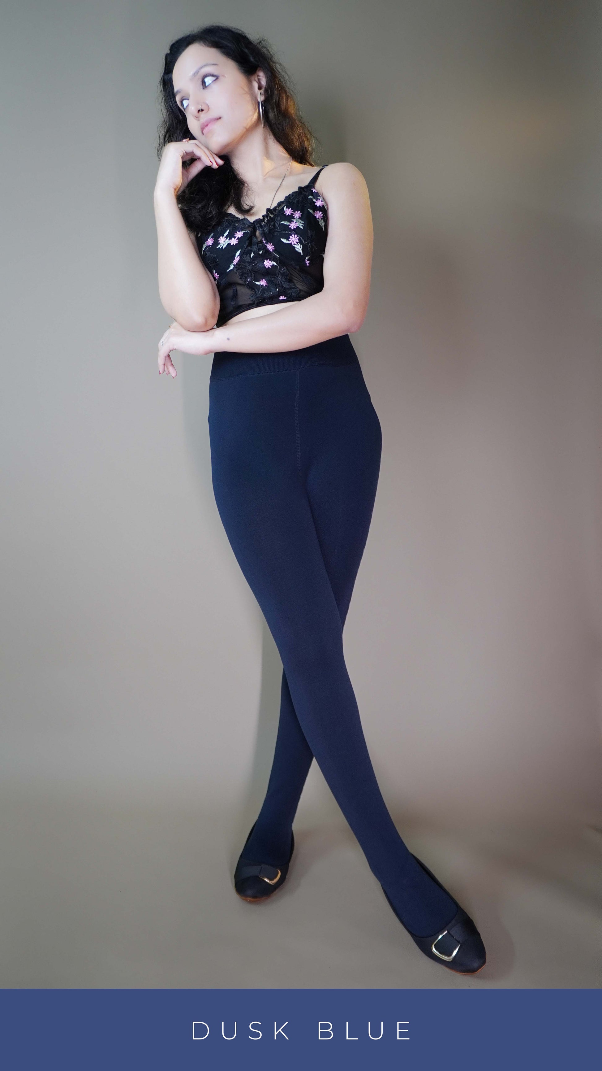 A model wearing furry bliss dark blue tights, posing elegantly against the light background, highlighting their soft, plush interior and perfect fit for ultimate winter comfort. -Muselot






