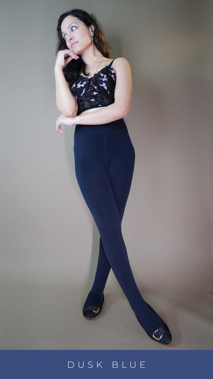 A model wearing furry bliss dark blue tights, posing elegantly against the light background, highlighting their soft, plush interior and perfect fit for ultimate winter comfort. -Muselot






