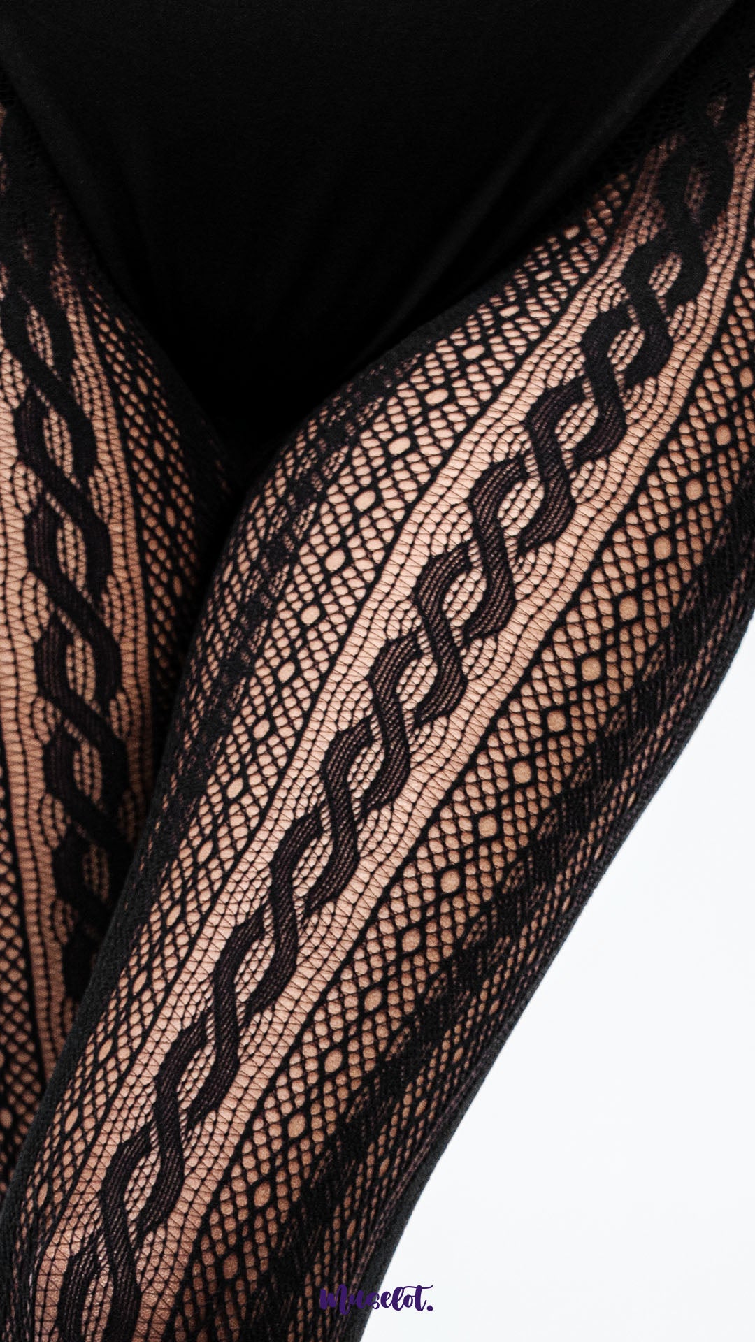 A close up of black mesh stockings on legs on white background, highlighting fine net texture and designer pattern detail for premium finish – Muselot