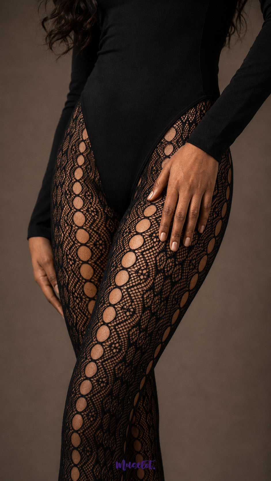 Close-up of black designer lace stockings showing intricate fishnet texture, floral lace detailing and a bold vertical row of oval openwork motifs along the legs.