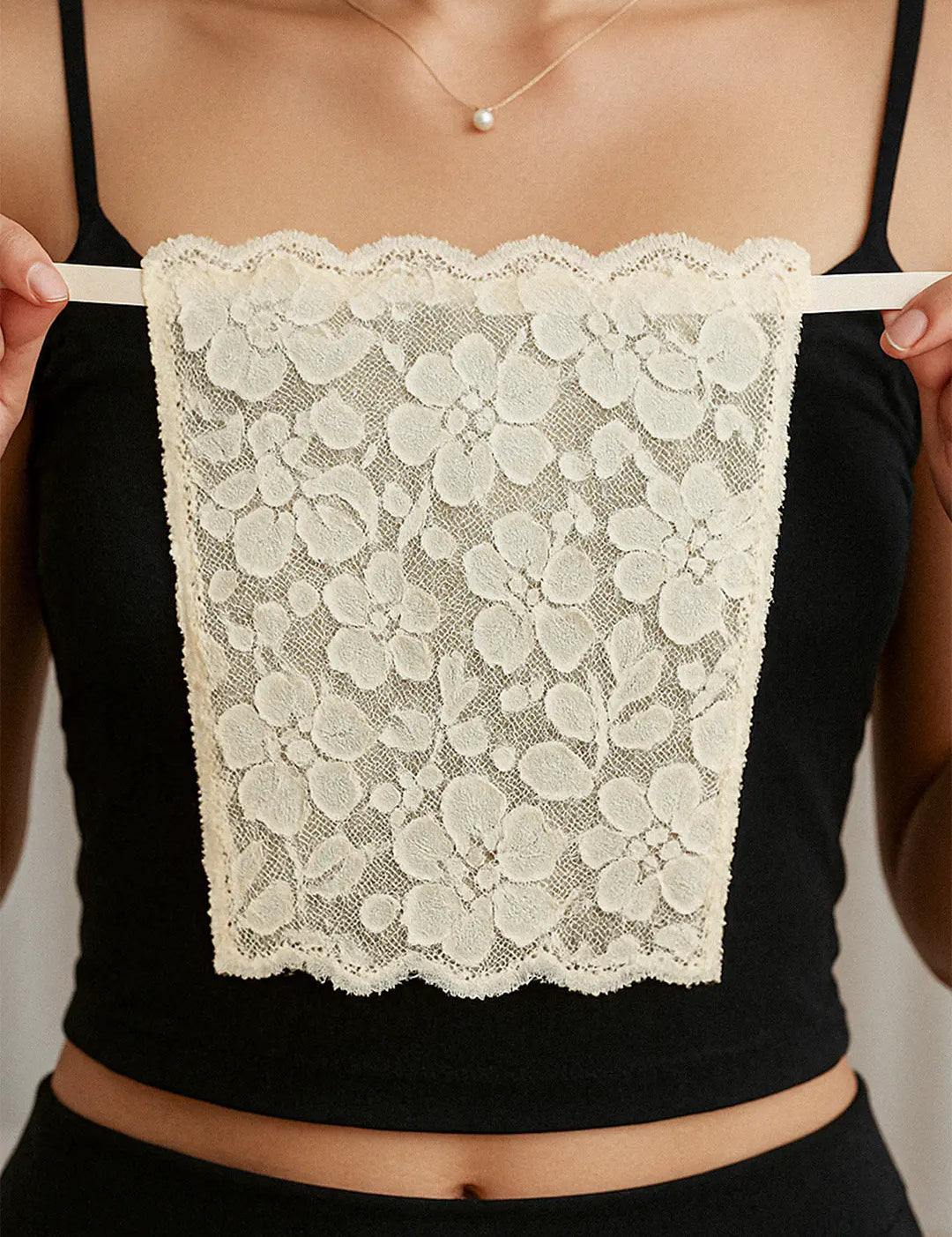 Close-up of model holding Lacy Beige Mockers, capturing the fine lacework and highlighting its graceful design for effortlessly styling deep-neck outfits – Muselot.