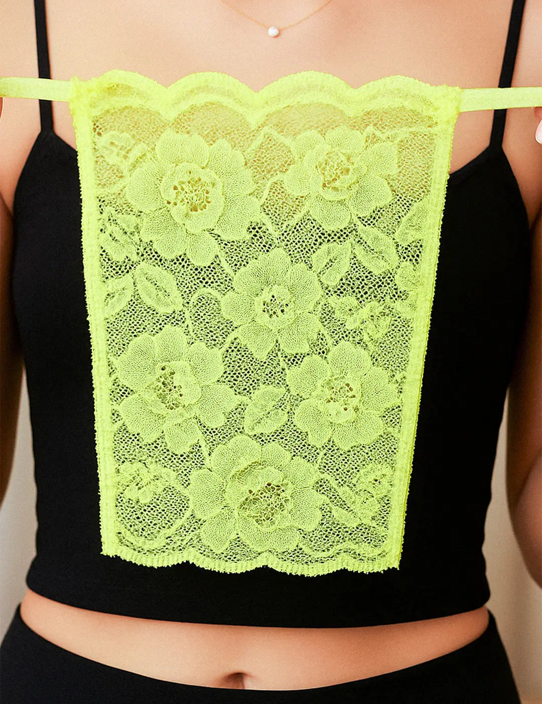 Close-up of model holding Lacy Neon Green Mockers, showcasing the vibrant lace detail and bold design that adds a striking touch to deep-neck outfits – Muselot.