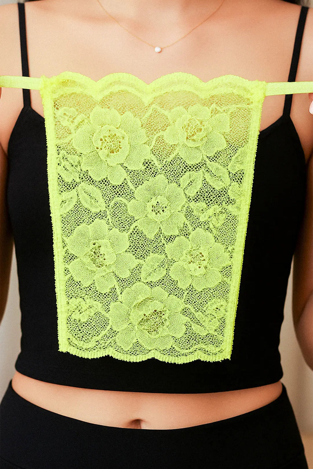Close-up of model holding Lacy Neon Green Mockers, showcasing the vibrant lace detail and bold design that adds a striking touch to deep-neck outfits – Muselot.