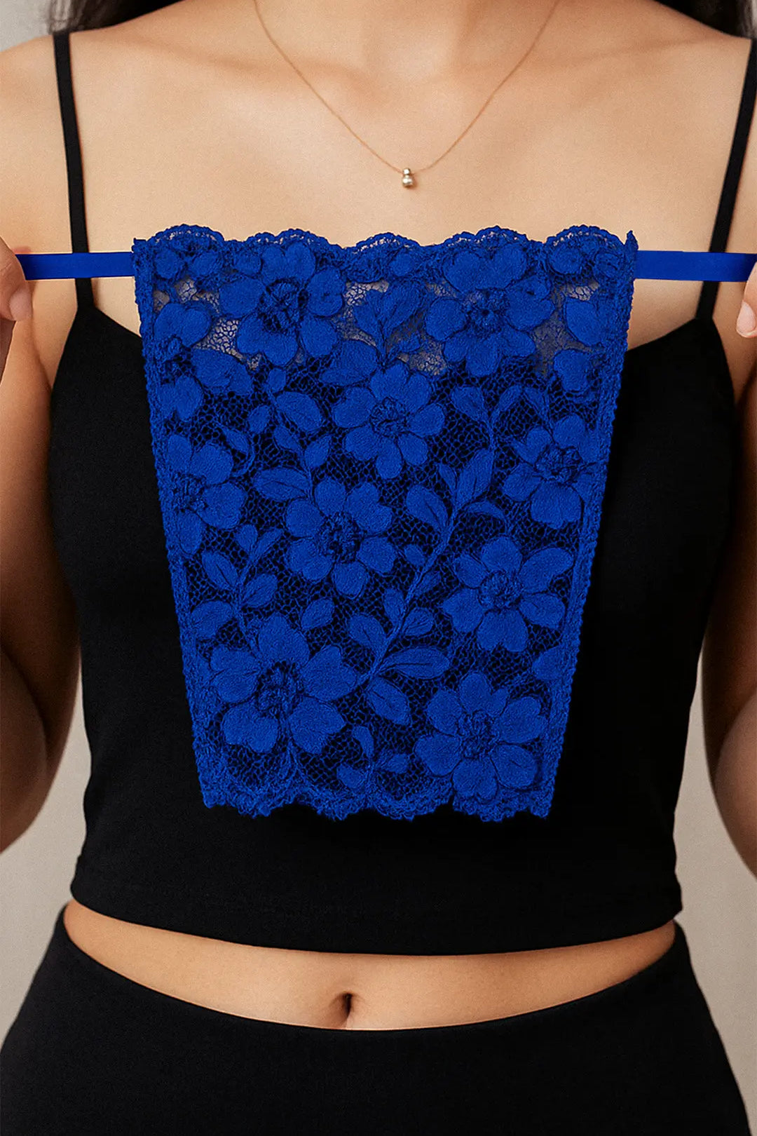 Close-up of model holding Lacy Royal Blue Mockers, showcasing the bold lace texture and rich color that elevates deep-neck outfits – Muselot.