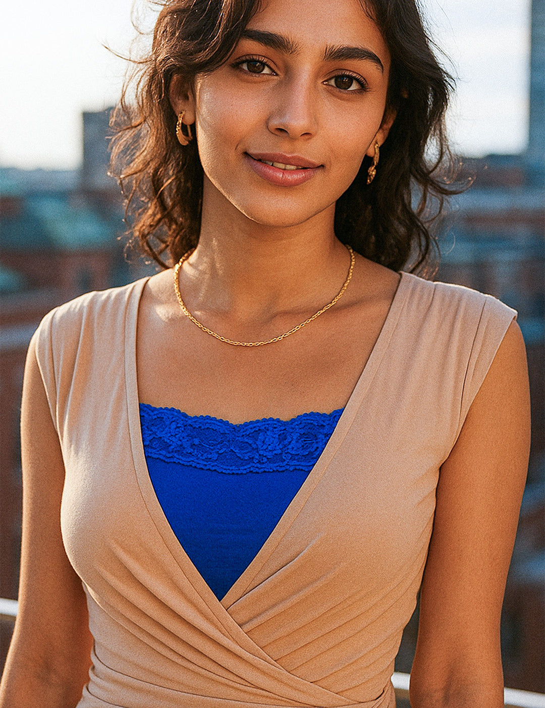 Model wearing royal blue lace mocker insert under a deep-neck outfit in an outdoor setting, highlighting vibrant lace details and elegant neckline coverage — Muselot.