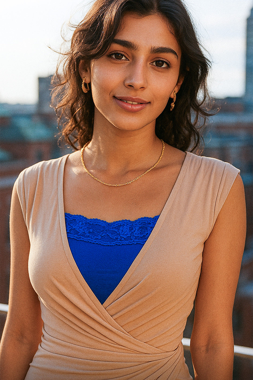 Model wearing royal blue lace mocker insert under a deep-neck outfit in an outdoor setting, highlighting vibrant lace details and elegant neckline coverage — Muselot.