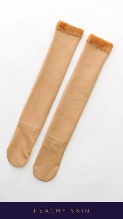 A shot of an pair of peachy skin-colored knee-high furry warm socks against a crisp white background, showcasing their tear-proof design and ultra-soft, plush texture, highlighting the durability and warmth of these socks-Muselot