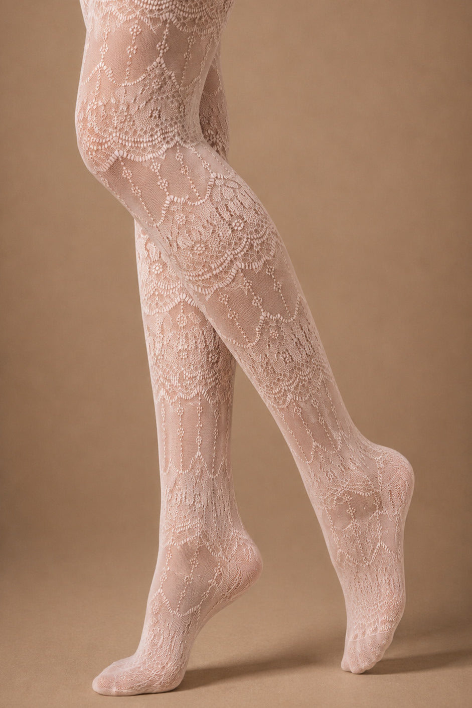 A detailed close-up of pearl pink lace stockings over the lower legs and feet, highlighting the continuous designer lace pattern and full closed-toe coverage – Muselot.
