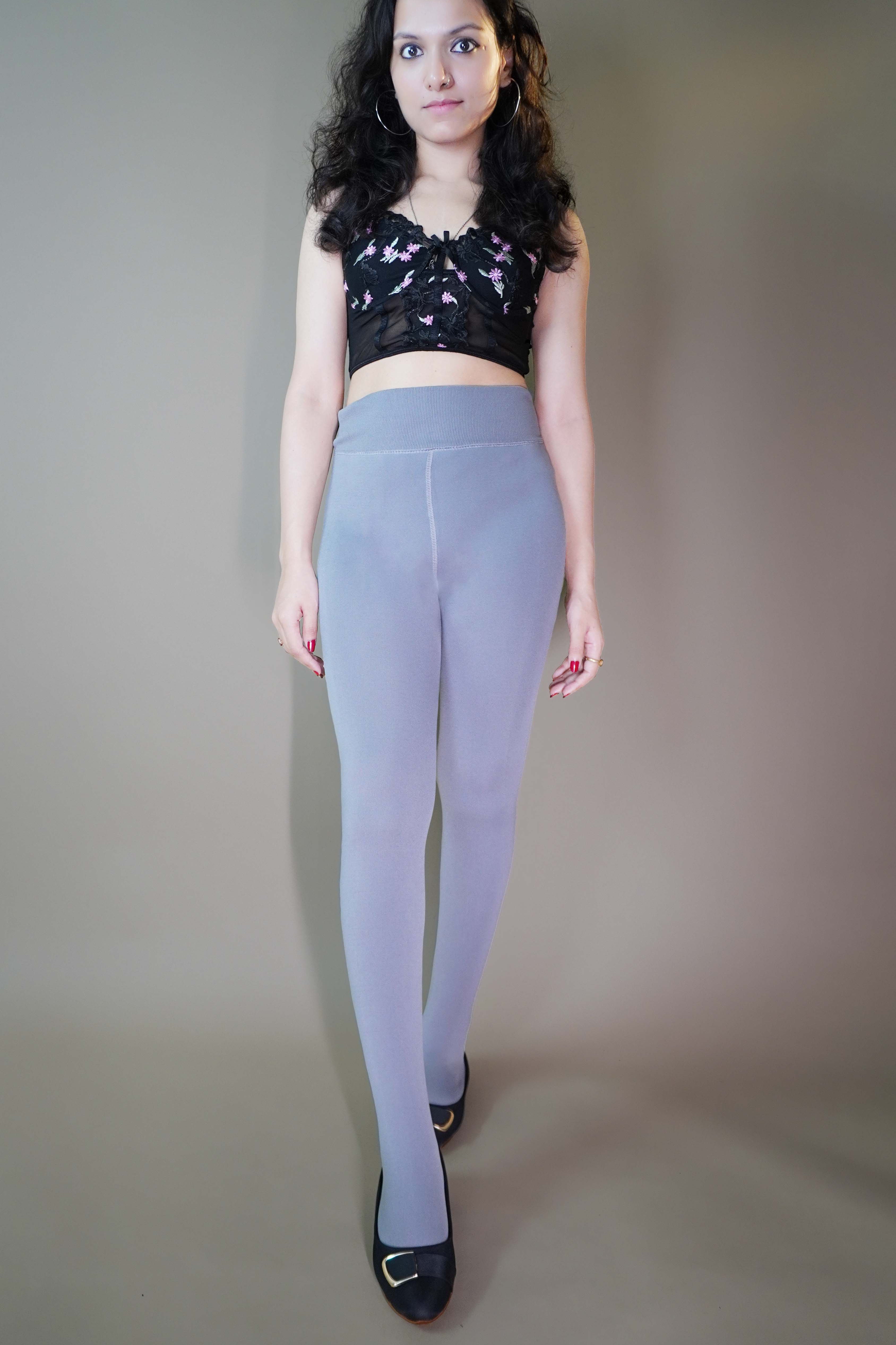 A model, wearing plush grey furry stockings, showcasing their soft, fluffy texture that provides exceptional warmth and comfort. The grey color highlights a cozy, stylish design, perfect for adding a touch of luxury to colder days. -Muselot