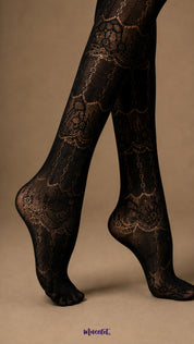 Close-up of black lace pantyhose covering the feet and lower legs, highlighting the detailed patterned mesh and closed-toe construction - Muselot