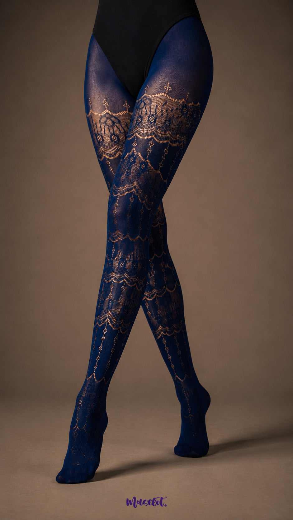 A close-up of crossed legs wearing Sapphire Blue designer stockings with intricate floral lace bands and semi-sheer patterned construction - Muselot