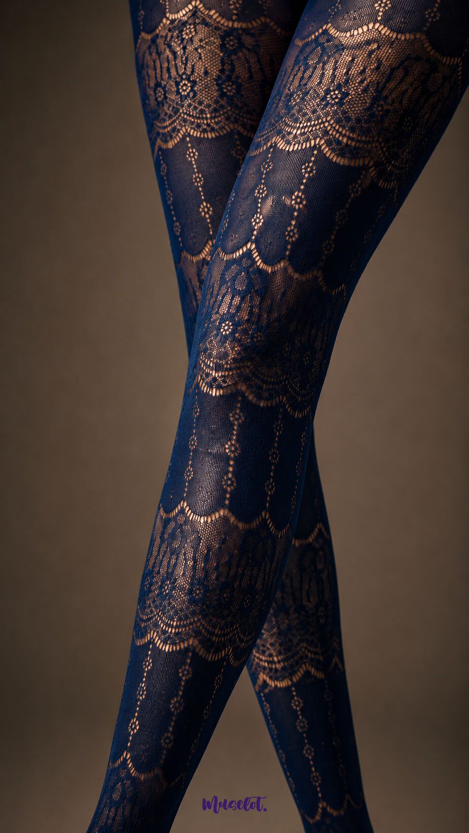 A zoom in view of Sapphire Blue patterned stockings featuring detailed floral lace bands, scalloped motifs and semi-sheer mesh sections - Muselot