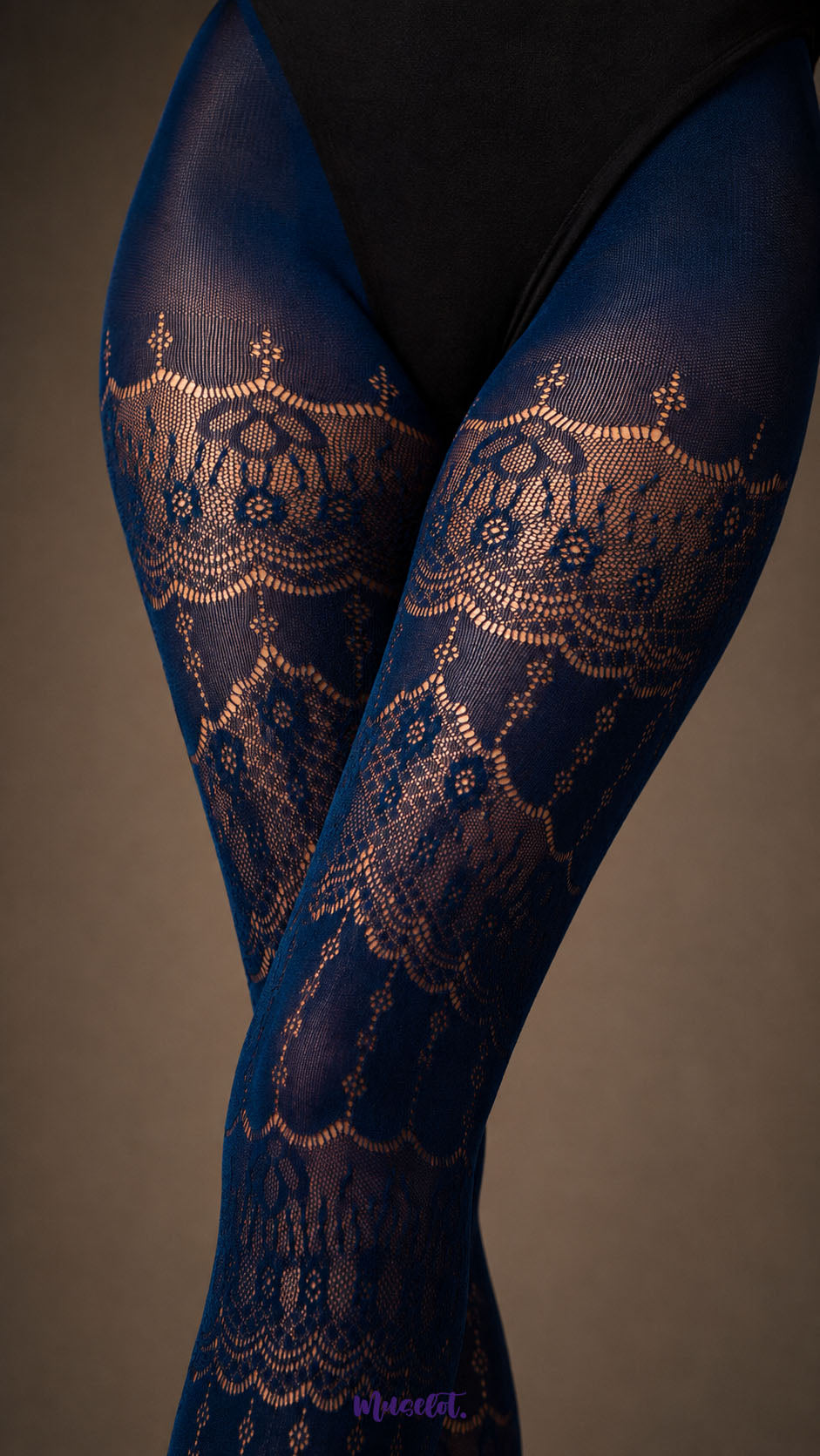 A close-up of Sapphire Blue designer lace pantyhose across the thighs showing intricate ornamental floral pattern and fine mesh texture - Muselot